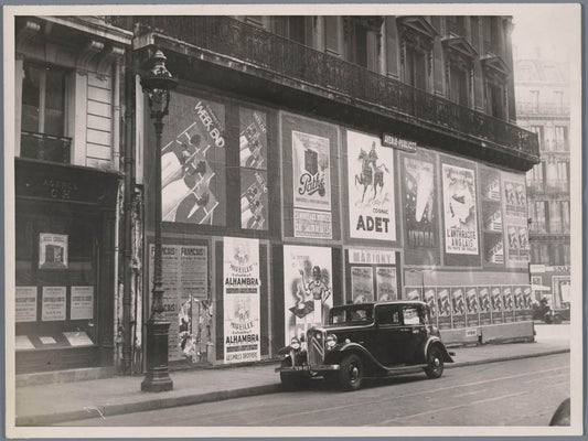 Car (Citroën) in front of a building covered with posters, Paris 0515-0001