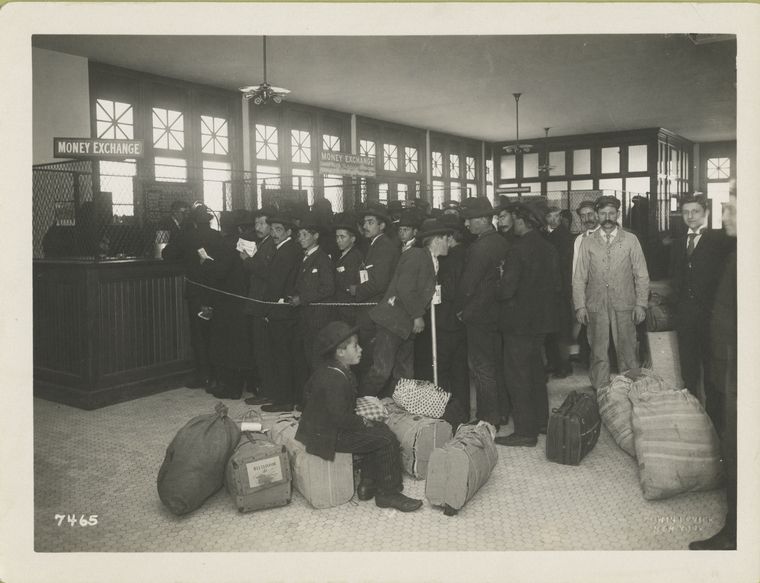 Ready for travel and going north, south and west. Immigrants with baggage lined up at teller's windows marked money exchange.
