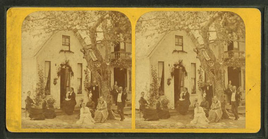 Group posed in front of a cottage.