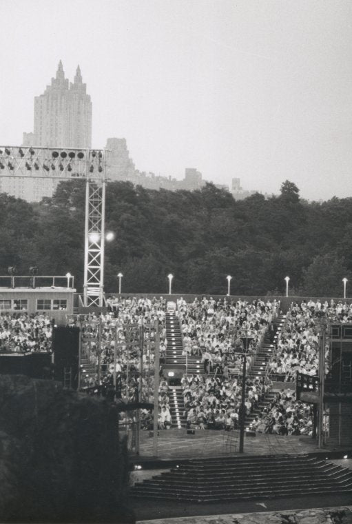 Audience members outdoors at Delacorte Theatre
